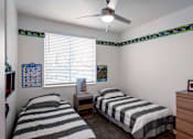 Thumbnail 45 of 61 - A bedroom with two beds and a ceiling fan.