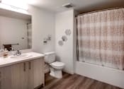 Thumbnail 42 of 61 - A bathroom with a toilet, sink, and shower curtain.