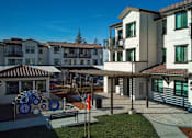 Thumbnail 39 of 61 - A sunny day at a courtyard with a white building and a small gazebo.