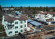 Thumbnail 13 of 61 - A large white building with a red roof is surrounded by a parking lot.