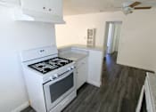 Thumbnail 13 of 17 - A white stove and oven in a kitchen with wood flooring.