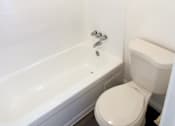 Thumbnail 14 of 17 - A white toilet sits next to a bathtub in a bathroom.