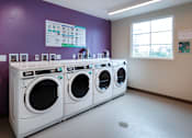 Thumbnail 109 of 127 - A row of white washing machines in a laundromat.