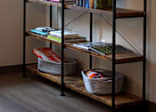 Thumbnail 112 of 127 - A black shelving unit with books, plants, and baskets on it.