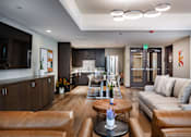 Thumbnail 120 of 127 - A modern living room with brown leather furniture and a wooden coffee table.