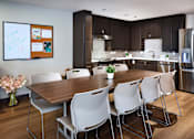 Thumbnail 125 of 127 - A modern kitchen with a dining table and chairs.