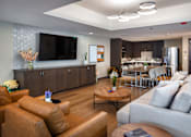 Thumbnail 122 of 127 - A living room with a brown leather couch and a wooden coffee table.