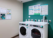 Thumbnail 103 of 127 - Two front loading washing machines in a laundry room.