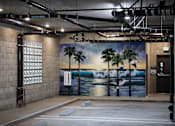 Thumbnail 95 of 127 - A wall mural depicting a beach scene with palm trees and waves.