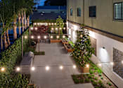 Thumbnail 88 of 127 - A building with a lit up walkway in front of it.