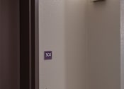 Thumbnail 80 of 127 - A brown door with a silver handle and a number 303 on the wall.