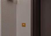 Thumbnail 73 of 127 - A brown door with a silver handle and a number 215 on the wall.