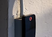 Thumbnail 76 of 127 - A black padlock with a red circle on the front is attached to a white pipe.