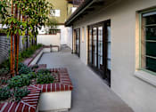 Thumbnail 78 of 127 - A long white building with a red brick planter in front.