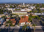 Thumbnail 56 of 127 - A view of a city from a high angle with buildings, palm trees, and a parking lot.