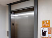 Thumbnail 66 of 127 - A stainless steel elevator with a sign on the wall.