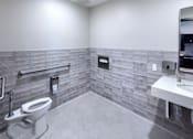 Thumbnail 67 of 127 - A bathroom with a toilet, sink, and tiled walls.