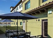 Thumbnail 40 of 127 - A patio with a table and chairs under an umbrella.