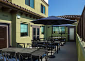 Thumbnail 41 of 127 - A patio with a table and chairs and an umbrella.