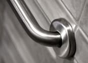 Thumbnail 47 of 127 - A close up of a stainless steel grab bar on a tiled wall.