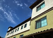 Thumbnail 35 of 127 - A building with a greenish-yellow facade and a blue sky with clouds in the background.