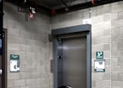 Thumbnail 30 of 127 - Two black bollards in front of a grey door.