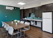 Thumbnail 33 of 127 - A kitchen with a table and chairs in front of a green wall.