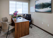 Thumbnail 44 of 127 - A room with a desk, chair, and a painting on the wall.