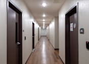 Thumbnail 32 of 127 - A long hallway with doors on both sides.