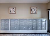 Thumbnail 13 of 127 - A row of grey lockers are lined up against a wall with two paintings hanging above them.