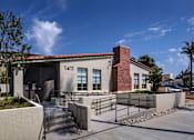 Thumbnail 5 of 127 - A modern building with a red brick chimney and a black gate in front.