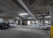 Thumbnail 25 of 127 - A parking garage with multiple cars parked.