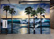 Thumbnail 7 of 127 - A mural of a sunset with palm trees and surfers.