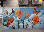 Thumbnail 6 of 127 - A mural of orange flowers and butterflies on a blue sky background.