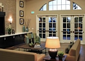 Thumbnail 86 of 117 - A well-lit living room with a couch, a table, and a fireplace.