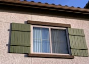 Thumbnail 80 of 117 - A window with green shutters on a beige wall.