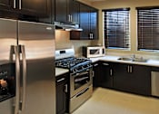 Thumbnail 115 of 117 - A modern kitchen with black cabinets and stainless steel appliances.