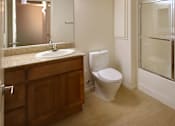 Thumbnail 117 of 117 - A bathroom with a toilet, sink, and mirror.