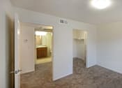 Thumbnail 52 of 117 - A room with a carpeted floor and a doorway leading to another room.