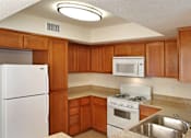 Thumbnail 112 of 117 - A kitchen with wooden cabinets and white appliances.
