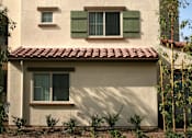 Thumbnail 34 of 117 - A house with a red tile roof and green shutters.