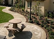Thumbnail 38 of 117 - A small outdoor table is in front of a building.
