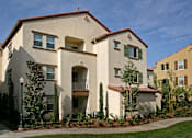 Thumbnail 28 of 117 - A building with a red tile roof and white walls with balconies.
