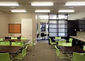 Thumbnail 51 of 117 - A conference room with green chairs and a brown table.