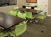 Thumbnail 43 of 117 - A conference room with a long table and green chairs.