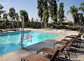 Thumbnail 25 of 117 - A pool with a ladder and chairs around it.
