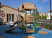 Thumbnail 21 of 117 - A playground with a slide and a brown roofed structure.