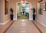 Thumbnail 44 of 117 - A hallway with a tiled floor and a chandelier hanging from the ceiling.