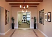 Thumbnail 40 of 117 - A hallway with a chandelier, potted plants, and framed pictures on the wall.