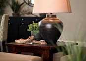 Thumbnail 45 of 117 - A table with a lamp and a vase on it.
